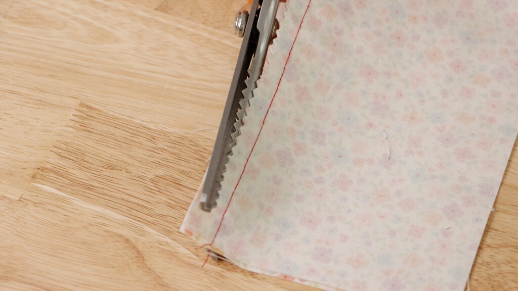 close-up of pinking shears cutting through fabric, showing the zigzag edge