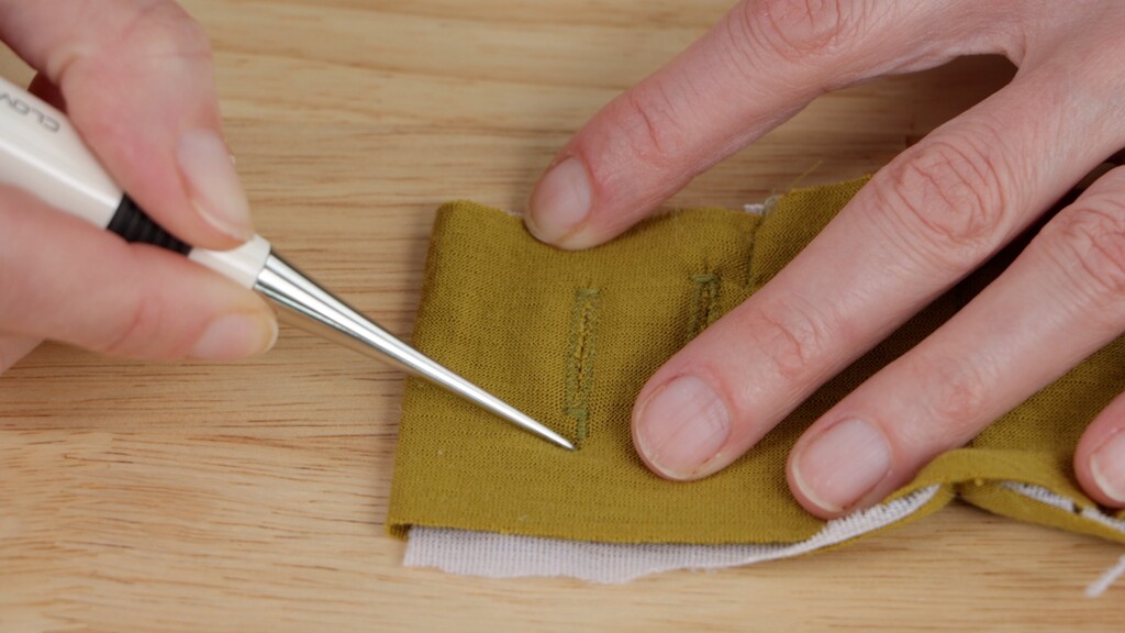 fabric scraps with various test stitches and techniques marked with notes